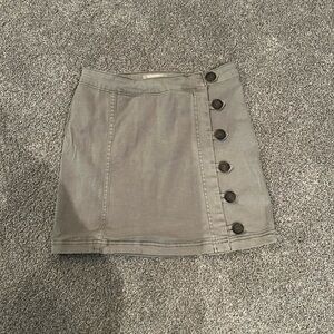 Grey mini skirt with button closure detail.